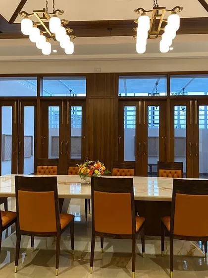 The same dining room viewed towards the full-length windows, which connect the space to the outdoors and can be opened to the veranda.