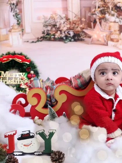 A beautiful, bokeh-filled Christmas scene. The soft, blurry lights in the background add a magical touch to this baby's holiday portrait.