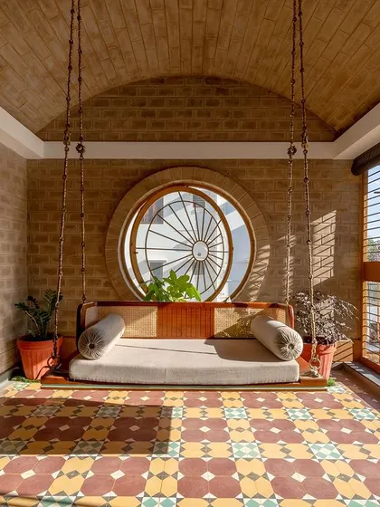 The full view of the swing, vaulted ceiling, and circular window.