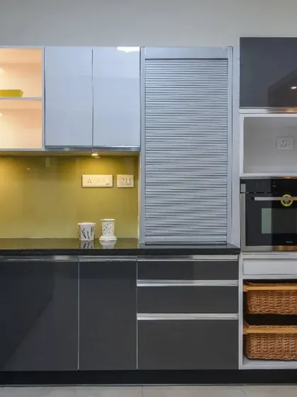 This image focuses on the storage solutions, including the tall unit with a built-in oven and wicker basket drawers.