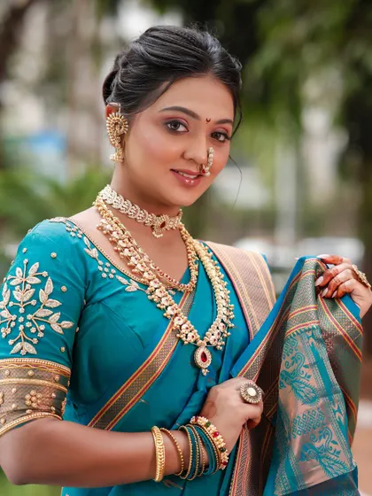 The model showcasing the complete look, including the stunning teal saree and traditional jewellery.