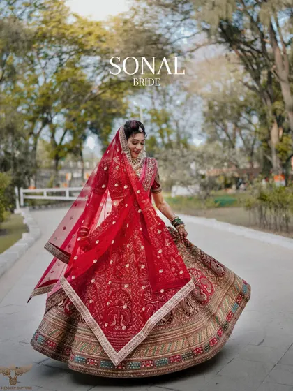 A classic, twirling bride shot. This portrait captures the movement and grandeur of the bride's red lehenga, creating a dynamic and joyful image.