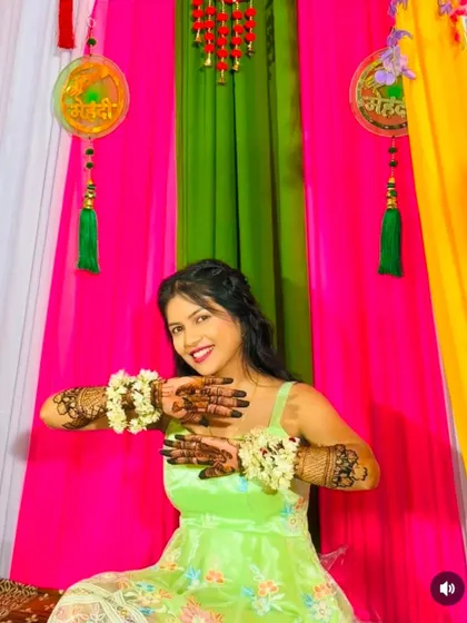 A graceful pose from a happy bride, showcasing her full-arm mehndi design.