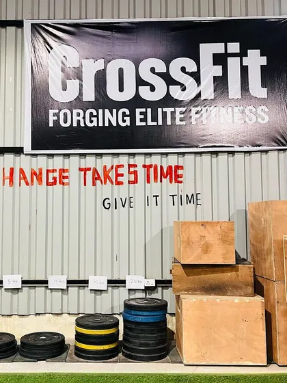 Change takes time, give it time. This message on our wall is a core part of our philosophy. You can also see our plyometric boxes and bumper plates, ready for the next workout.