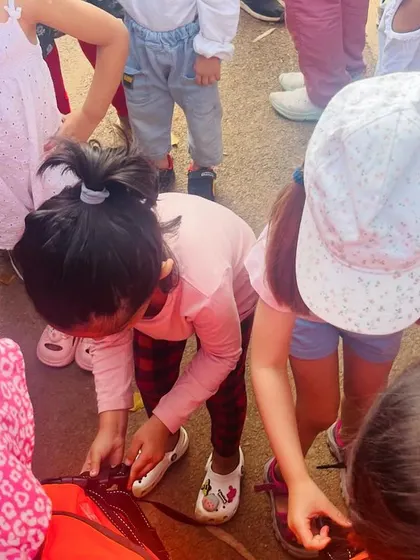 Children get to touch and explore parts of the firefighter's equipment, making the experience tangible and memorable.