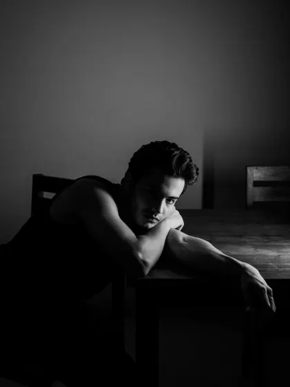 A moody, low-key portrait. The deep shadows create a sense of introspection and drama.