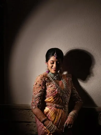 An artistic shot of the bride, with the spotlight on her beautiful smile and her intricately embroidered blouse.