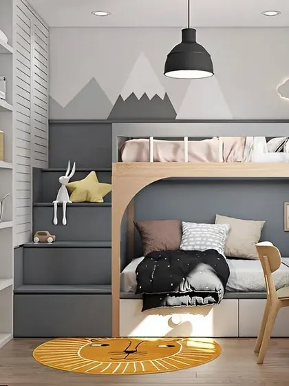 This modern kids' room features a grey and wood bunk bed with integrated stairs that double as storage. A compact desk is placed next to the bed, and a lion-themed rug adds a playful touch to the room.
