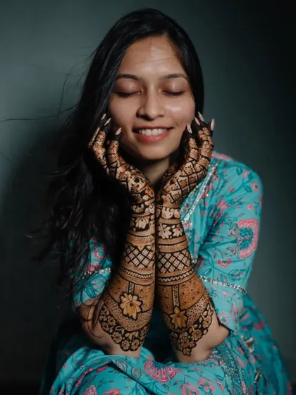 A happy bride showing off her completed Mehendi. Her joyful, satisfied smile says it all, and we were there to capture it.