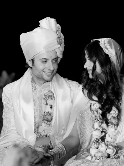 A classic black and white portrait of the couple sharing a smile during their wedding ceremony.