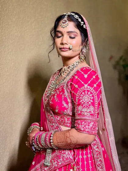 A serene moment captured in a stunning pink bridal lehenga. The intricate silver work and matching jewellery create a truly memorable look.