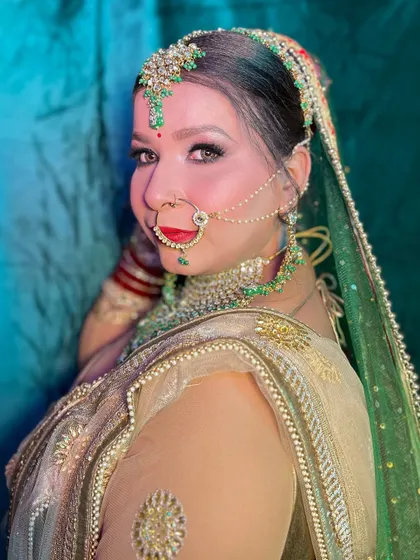 The side profile of this bridal look, highlighting the elegant bun, the drape of the dupatta, and the perfectly contoured cheekbones.