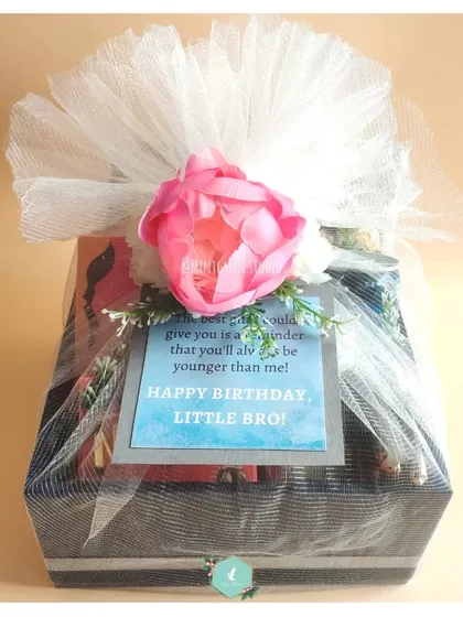 A hamper for a little brother, wrapped beautifully with a pink peony and a personal note. The wrapping makes the gift feel extra special.