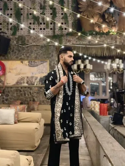 The festive lights of Diwali are the perfect backdrop for this embroidered kurta and shawl set. The intricate patterns add a layer of texture and luxury to the look.