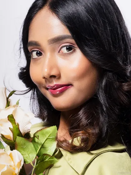 A close-up of a model holding roses, with a soft and gentle expression.