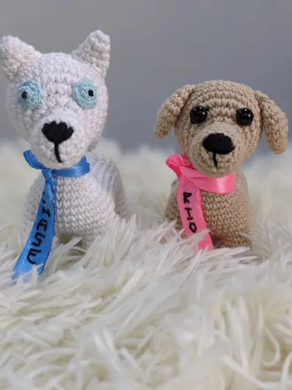 A pair of custom crochet dogs, Rio and Chase, made to look like a client's pets. Each one has a ribbon collar with their name written on it.