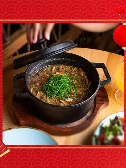 A hot pot of savory Schezwan soup, garnished with fresh greens. This dish offers a perfect balance of heat and flavor for an adventurous palate.