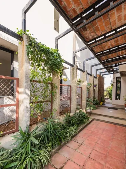 The entryway of the Samvrruddhi home, designed with a pergola and precast concrete panels. Creepers and plants are encouraged to grow over the structure, creating a living, breathing entrance.