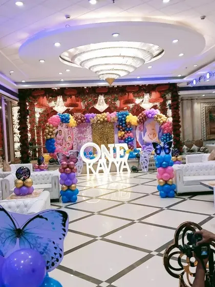 A wide view of the grand butterfly-themed setup for Kavya's first birthday. I can transform any banquet hall into a colorful wonderland, from the main stage to the entrance and seating area.