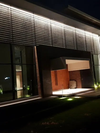 The lighting for the residence of the CEO of Lally Motors. The design uses subtle ground-level uplighting and a continuous wash of light along the top of the facade to create an understated yet powerful effect on the modern structure.