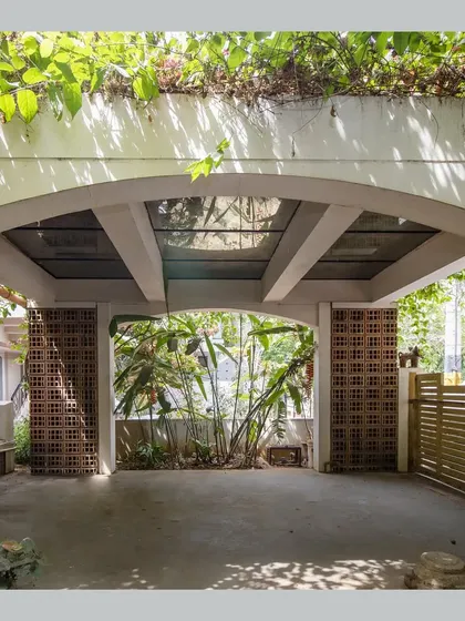 The car porch is covered by a 'flowering roof', a type of green roof, with a glass section to allow light through.