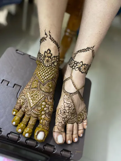 A beautiful example of asymmetrical foot mehendi. One foot has a heavy, full-coverage design while the other has a lighter, complementary pattern.