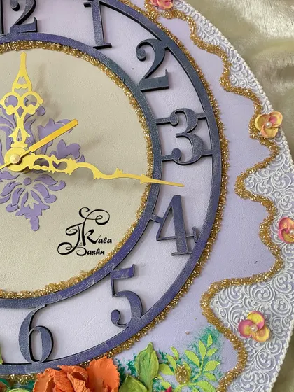 A close-up of the unique lavender wall clock, focusing on the modern numerals and central stencil design.