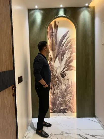 A finished hallway feature. The arched niche with botanical wallpaper and fluted panels creates an elegant and artistic statement.