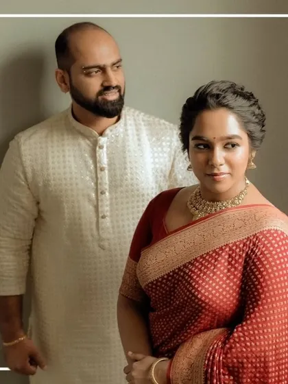 A classic portrait of a couple in red and white traditional wear.