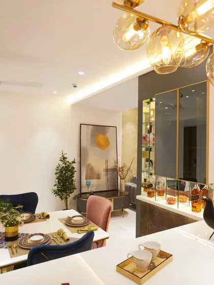 A dining area from one of my projects in the Lodha Complex, featuring a modern bar, statement lighting, and a mix of colorful dining chairs.