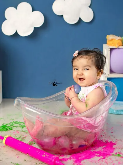 All smiles in the splash tub! This photo captures the pure delight of a baby enjoying a warm bath after getting messy with colors.