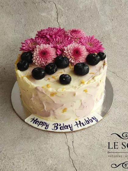 A rustic Lemon Blueberry Cream Cheese cake. Since cream cheese frosting is softer, a rustic finish like this is perfect, and it looks beautiful topped with fresh blueberries and pink flowers.