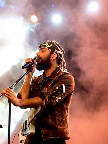 On stage with my guitar, surrounded by stage smoke and lights. This captures the rock and roll side of our performances.
