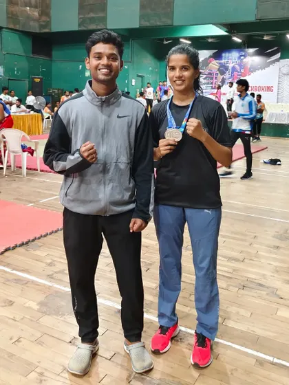 A moment of pride between coach and student. One of our athletes poses with her coach after winning two silver medals at the state-level championship, a result of their shared dedication.
