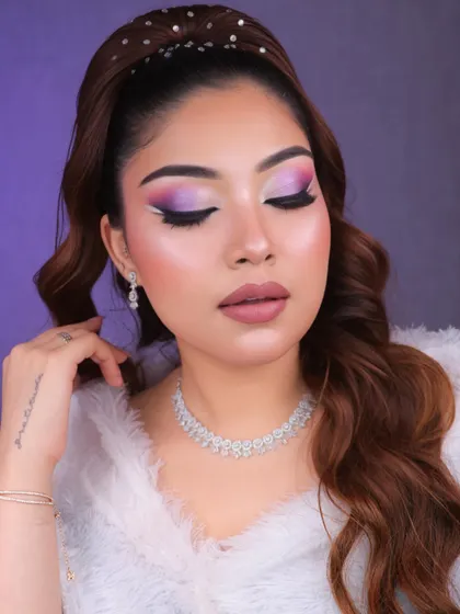 A creative and glamorous look featuring a blend of pink and purple eyeshadows with a sharp white graphic liner.