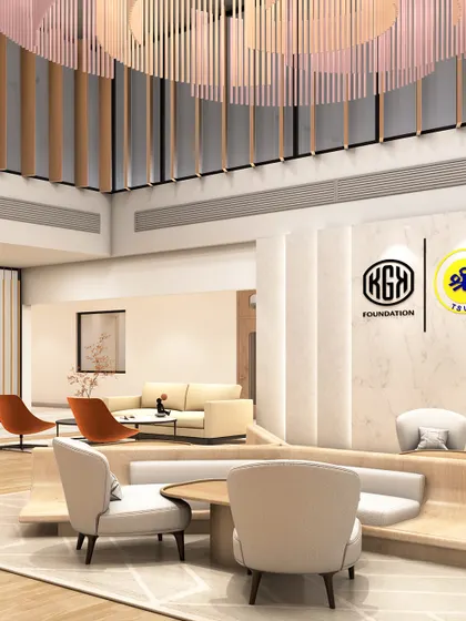 This angle of the school's waiting area highlights the built-in curved seating and the interplay of different textures, from the smooth marble wall with logos to the warm wood flooring.