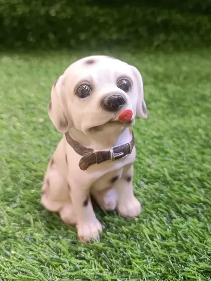 A sweet Dalmatian puppy figurine, captured with its tongue playfully sticking out.