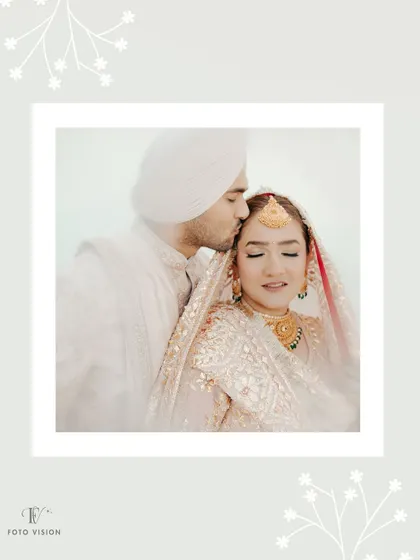 A soft, romantic portrait of the groom kissing the bride's forehead, framed by a delicate white border for an artistic touch.