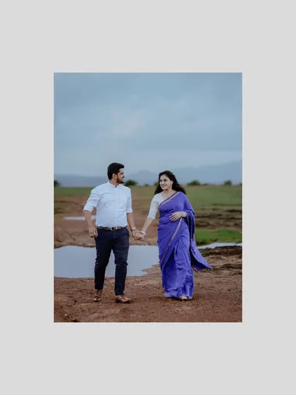 A simple, centered shot of the couple walking hand-in-hand through a rustic field, capturing a quiet moment of their journey together.