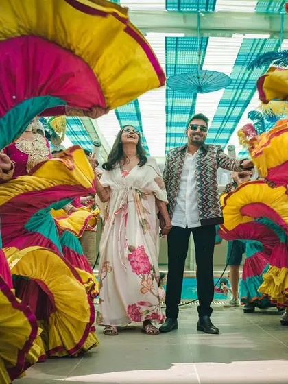 Another angle of the vibrant carnival entry, showcasing the colorful swirling skirts of the dancers that create a tunnel of color for the couple.