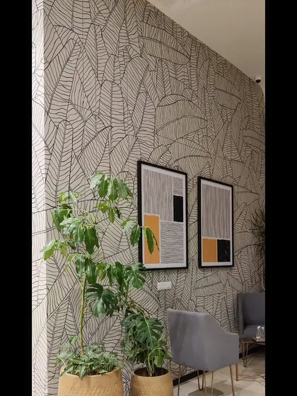 The line art mural serves as a sophisticated backdrop for framed art and minimalist furniture in this corporate space.