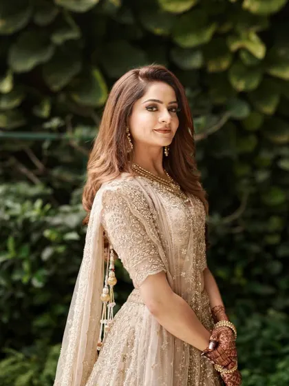 An engagement bride in a stunning beige anarkali. The makeup is soft and golden, creating a warm and romantic look.