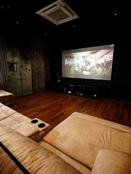 A view from the side of the sofa, showing the large screen and the heavy curtains that can be drawn to block out all ambient light.