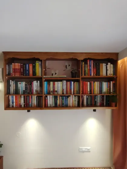 The bookshelf filled with books, demonstrating its ample storage capacity. The elegant design makes it a stunning feature in the bedroom.