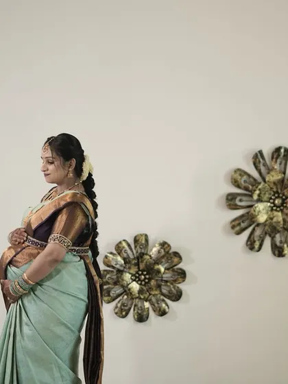 A side profile of Ranjitha, showcasing the beautiful drape of the saree and the fit of the custom blouse.