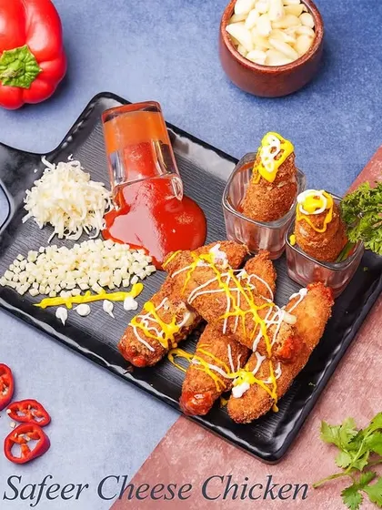 Our Safeer Cheese Fingers are crispy on the outside with a cheesy, flavorful chicken filling. They are served with a variety of sauces and garnishes, making for a fun and interactive appetizer.