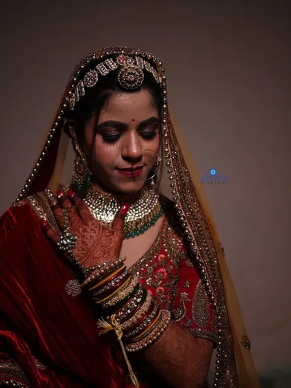 A classic bridal portrait capturing the rich texture of the velvet lehenga and the intricate details of the bride's bangles and jewelry.