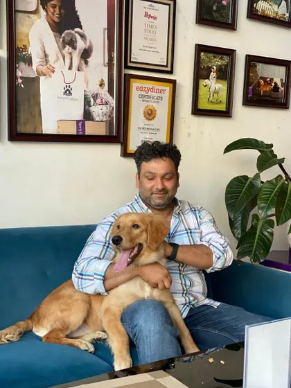 Pure comfort and happiness. A pet parent shares a cuddle with their Golden Retriever on our cozy café couch.