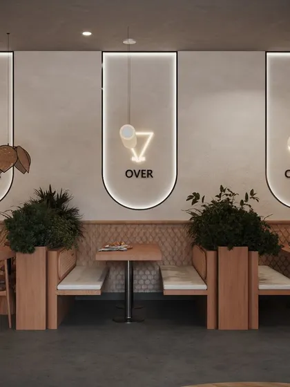 The feature wall behind the booths combines minimalist backlit frames with fun neon icons, adding a playful and trendy element to the cafe's design. This area shows our skill in creating Instagrammable moments within a space.