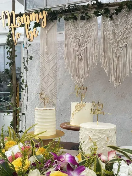 For a more modern take on a baby shower, I designed this lovely boho-chic setup. It features a beautiful macrame backdrop, a custom "Mommy to be" sign, and a dessert table adorned with fresh flowers.